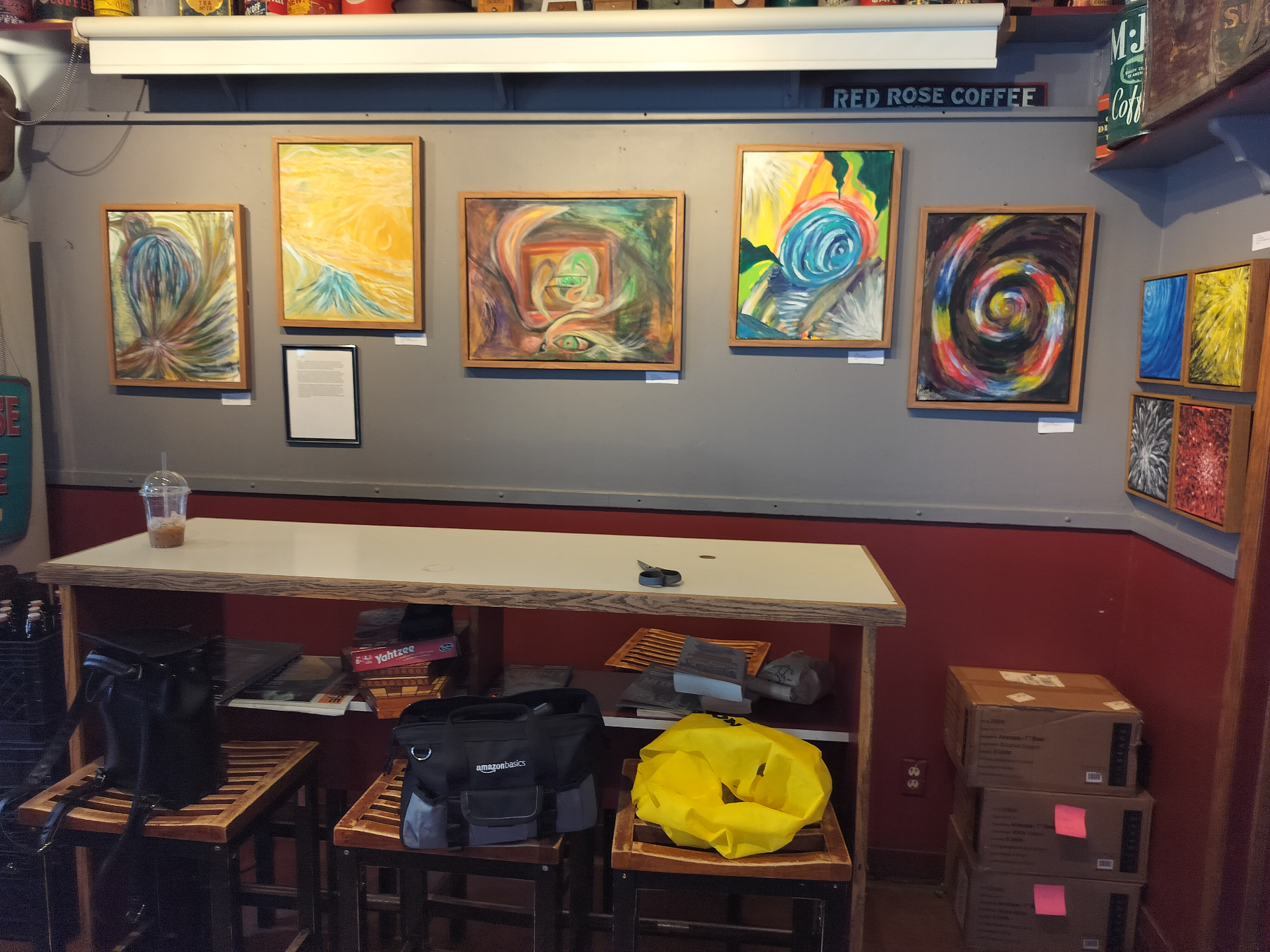 Calgary café featuring local artists' framed work on a sunlit brick wall